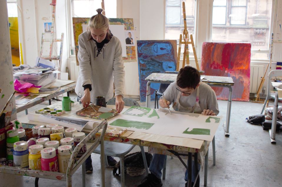 volunteer helping artist at project ability