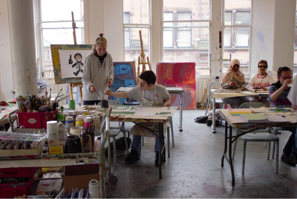 volunteer helping artist at project ability