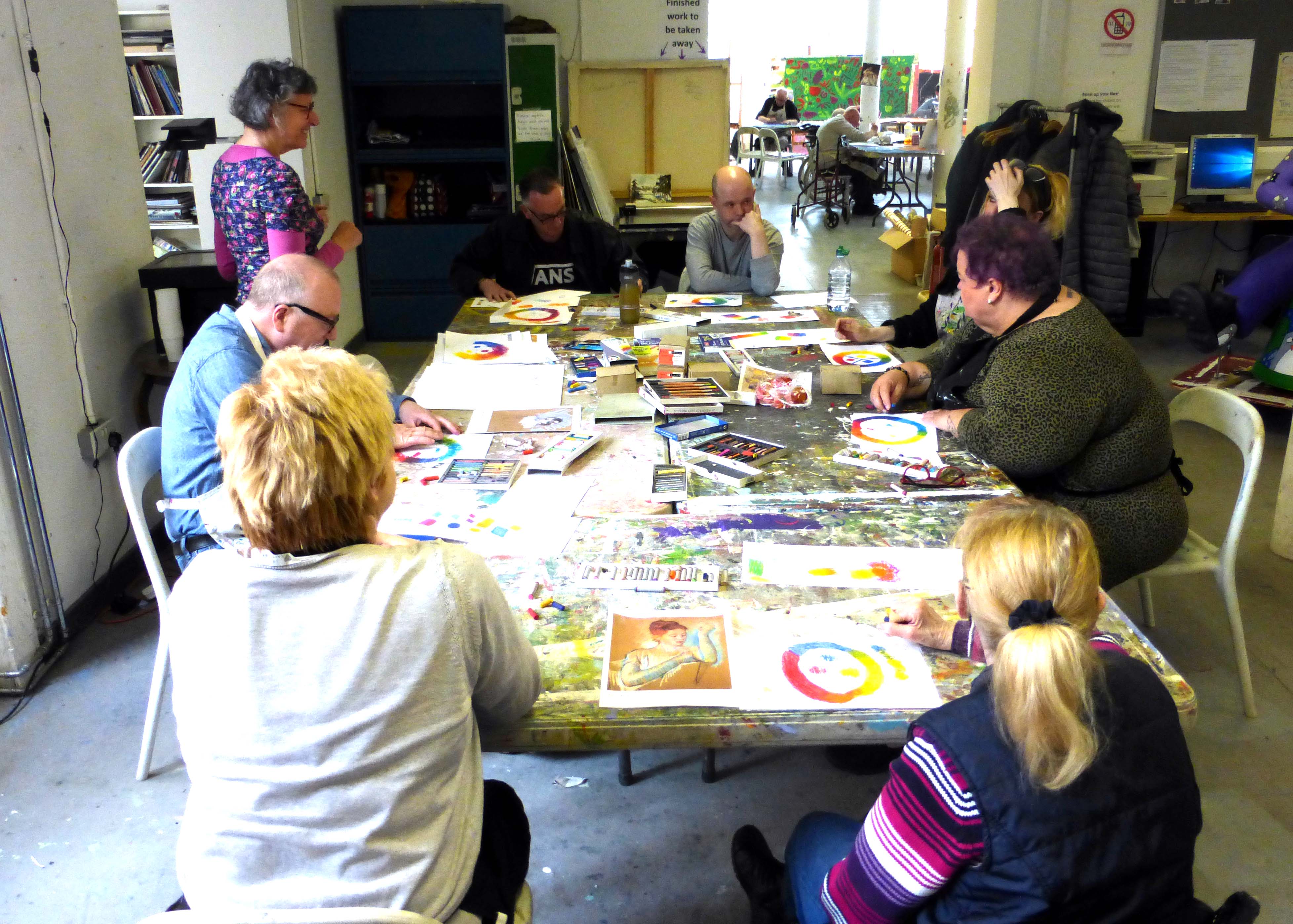 volunteer at table helping artists at Project Ability 
