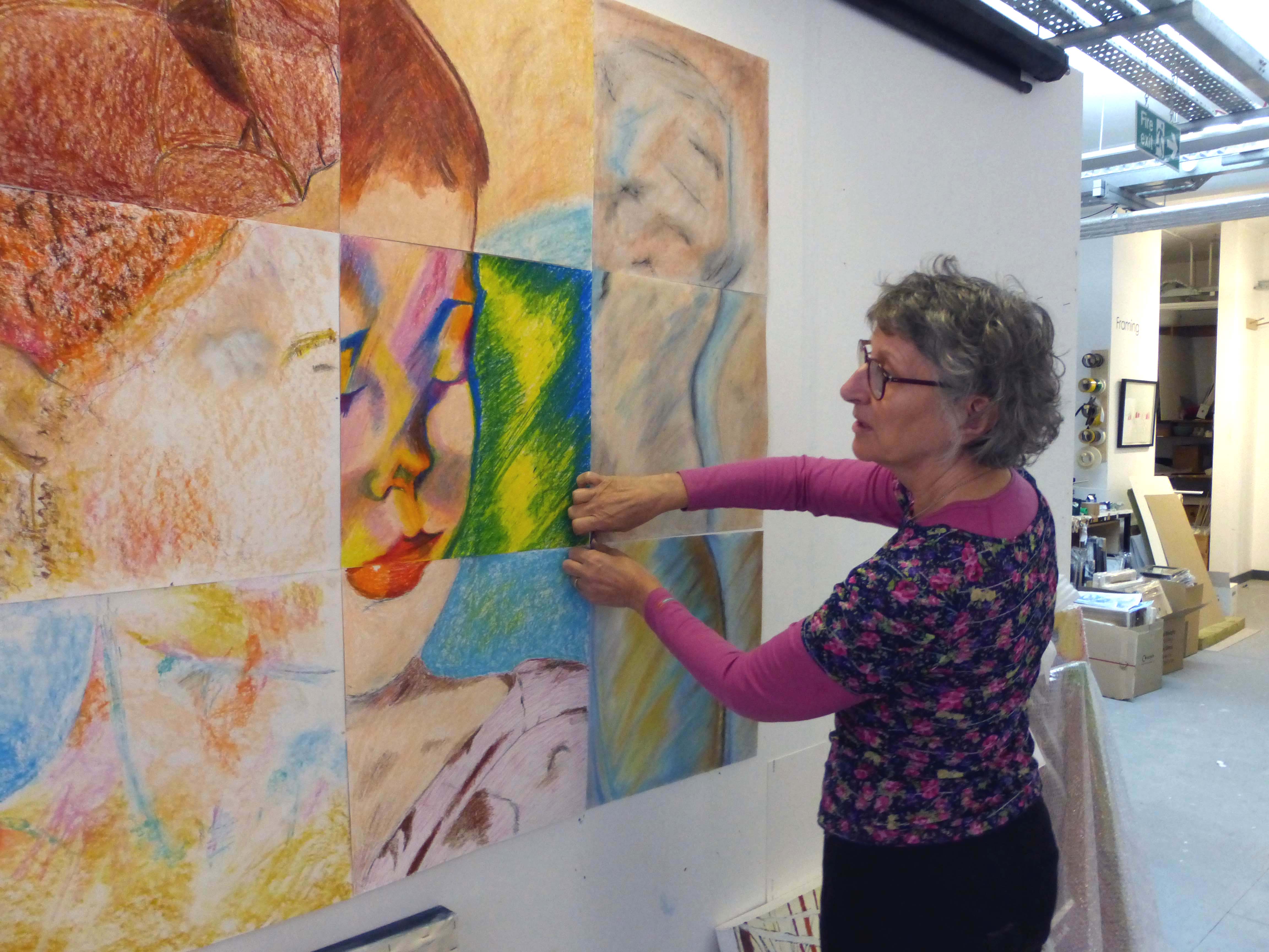 volunteer putting up artists work at Project ability