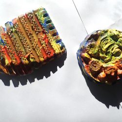 two colourfully painted ceramic shapes