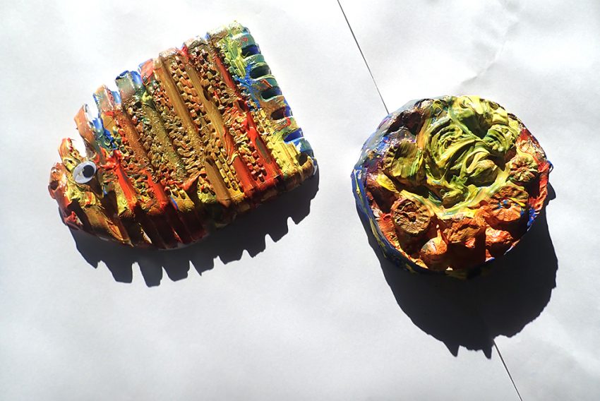 two colourfully painted ceramic shapes