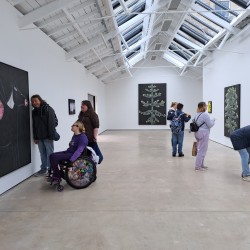 artists from the walking group looking at artwork in an exhibition