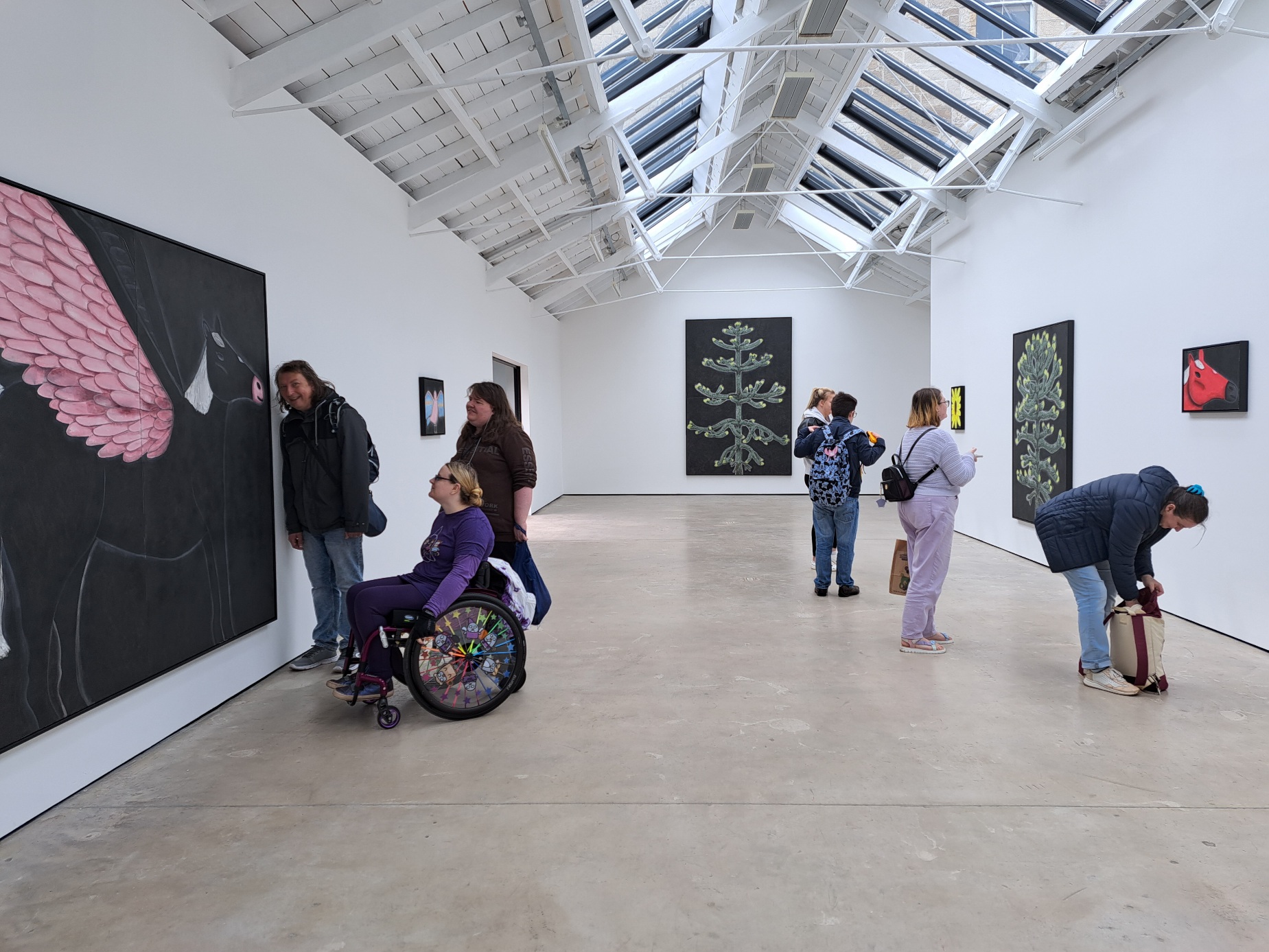 artists from the walking group looking at artwork in an exhibition