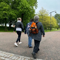 3 members of the grouop walking down a path in Glasgow Green