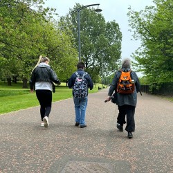 people walking down a path in the middle of the park