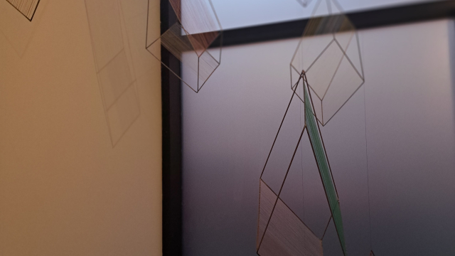 Several hanging geometrical shapes and forms, made with thin wire.