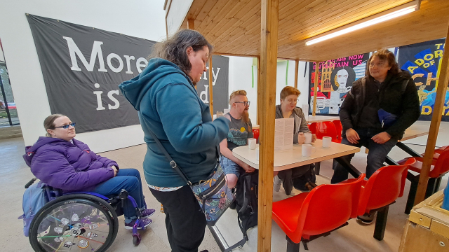 A group of people gather in a pop up café space in a gallery.