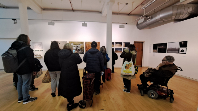A group of people gather in a spacious gallery.