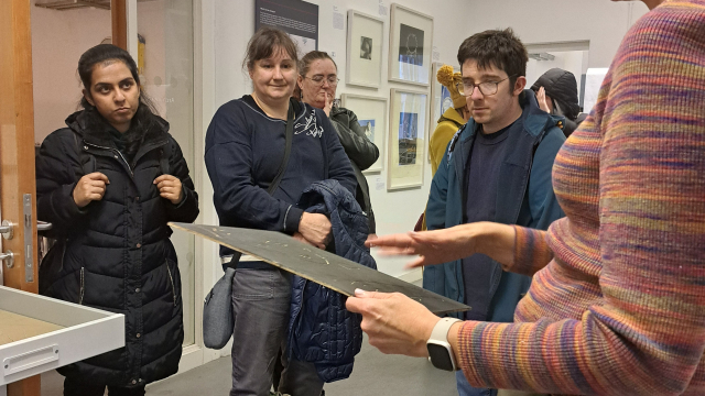 A group of people listen to an archive worker's explanation of the space and how it's used.