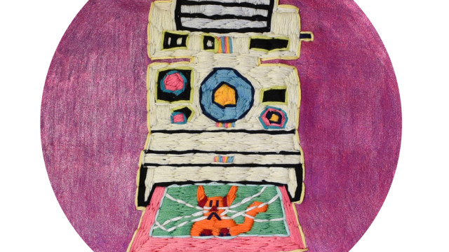 An embroidery of a white polaroid camera printing out an image of a cat, on a purple fabric background.
