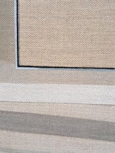 A close up of one the paintings. It shows the corner and the detail of the painting made to look like the textured canvas